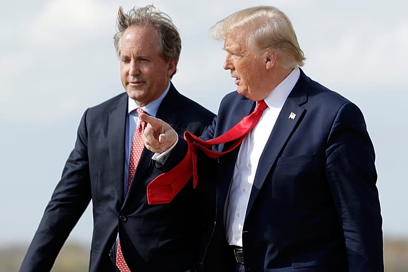 President Donald Trump walks with Texas Attorney General Ken Paxton, left, at Austin-Bergstrom International Airport in Austin, on Nov. 20, 2019. (AP Photo/Evan Vucci)