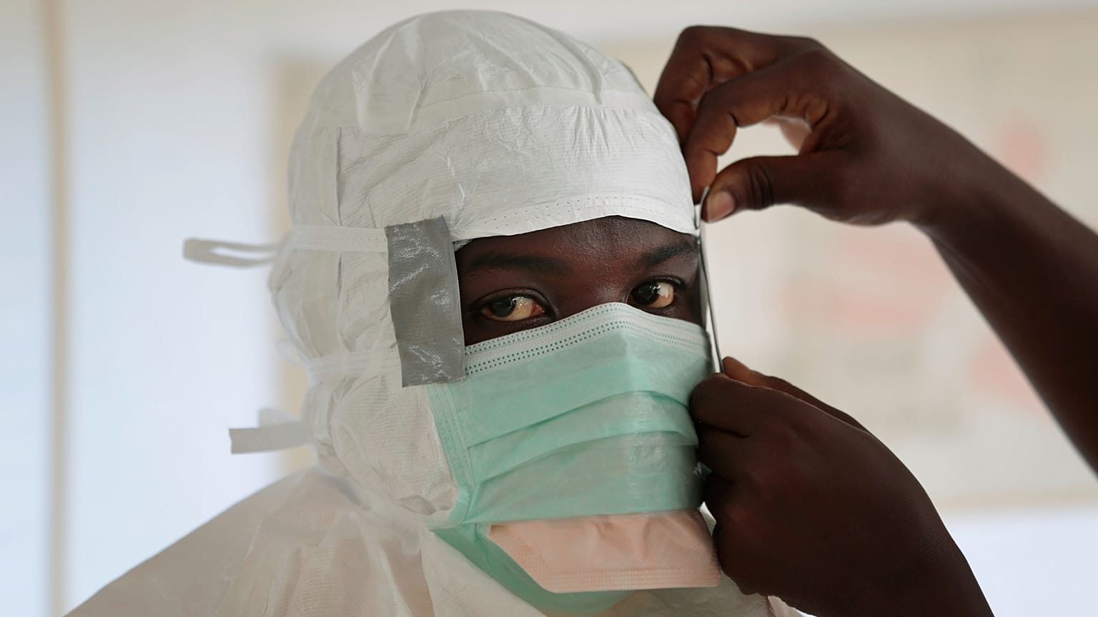  Un'infermiera indossa i dispositivi di protezione individuale prima di entrare in una zona ad alto rischio in un centro di cura dell'Ebola di MSF