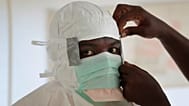  Un'infermiera indossa i dispositivi di protezione individuale prima di entrare in una zona ad alto rischio in un centro di cura dell'Ebola di MSF