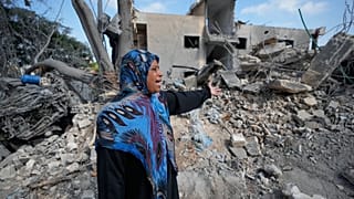 امرأة تقف قرب أنقاض منزلها الذي دمرته غارة إسرائيلية في بلدة معركة جنوب لبنان، في 27 مايو 2026.