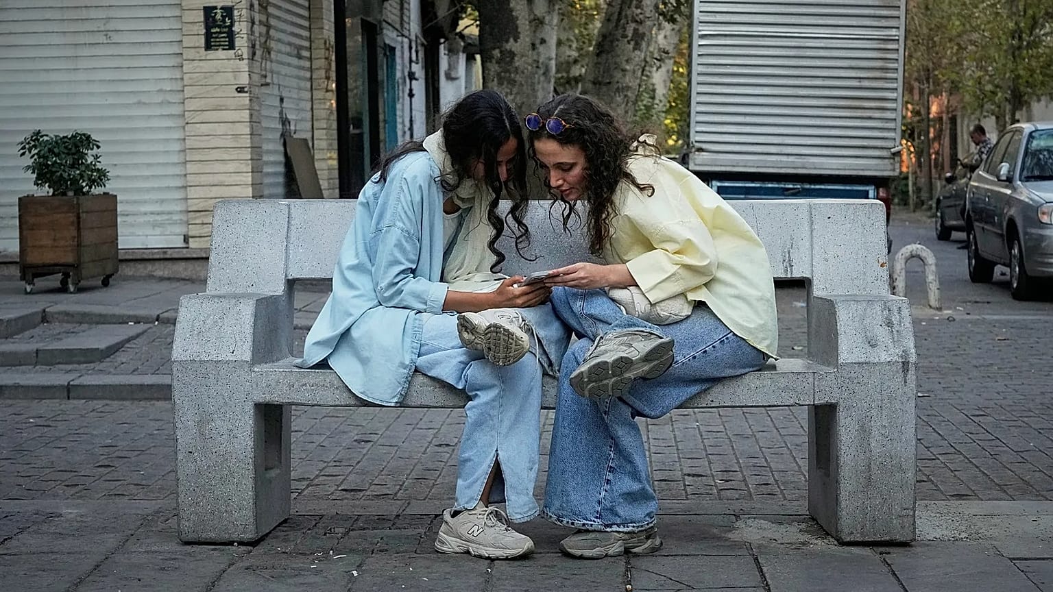 FILE - Two women use a smartphone in northern Tehran, Iran, Sept. 28, 2025. (AP Photo/Vahid Salemi, File)