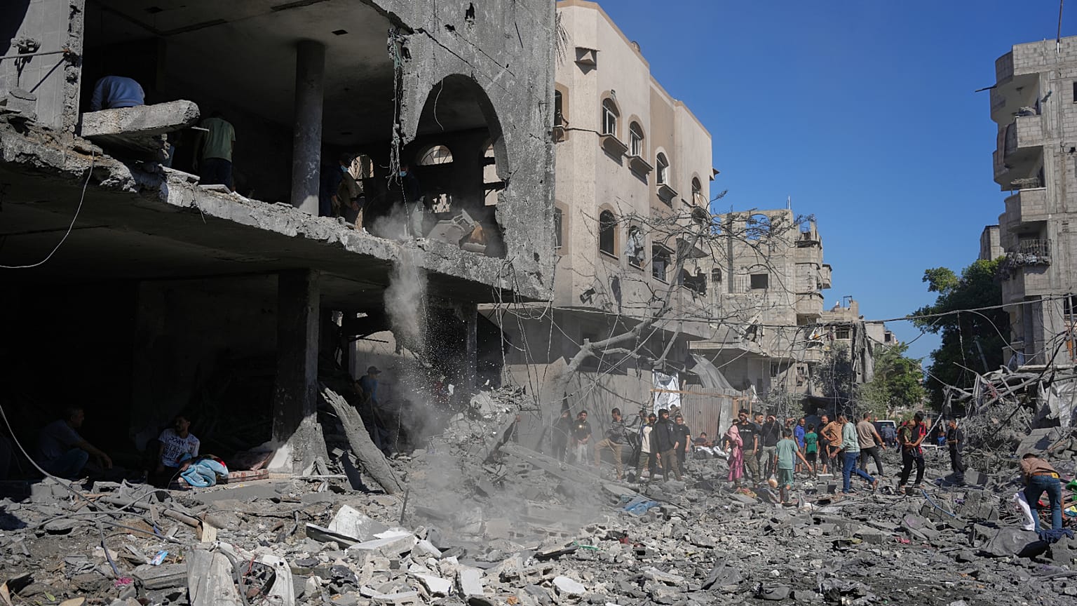 فلسطينيون يتفقدون أنقاض مبنى دمر في غارة جوية إسرائيلية في النصيرات بوسط قطاع غزة، الثلاثاء 26 مايو 2026. (AP Photo/عبد الكريم حنا)