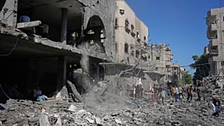فلسطينيون يتفقدون أنقاض مبنى دمر في غارة جوية إسرائيلية في النصيرات بوسط قطاع غزة، الثلاثاء 26 مايو 2026. (AP Photo/عبد الكريم حنا)