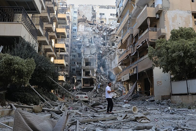 A man checks the site of destroyed buildings that were hit in Israeli airstrikes in the southern port city of Tyre, Lebanon, Thursday, May 28, 2026. 