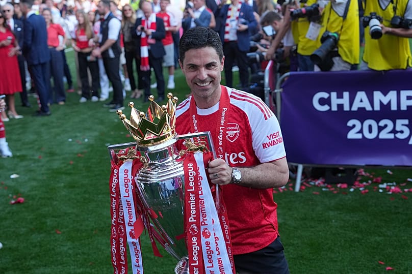 Mikel Arteta, az Arsenal edzője a trófeát tartja a kezében, miközben a csapat a Premier League-bajnoki cím megszerzését ünnepli a Crystal Palace és az Arsenal közötti angol Pr