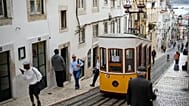ARQUIVO - Pessoas passam junto ao funicular da Bica, estacionado em Lisboa