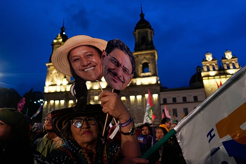 Un sostenitore di Iván Cepeda, della coalizione di governo Pacto Histórico, tiene in mano sagome di Cepeda e della sua candidata alla vicepresidenza, Aida Quilcue, a Bogotá, il 22 maggio 2026.
