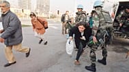 ARCHIVIO, 21 novembre 1994: Residenti di Sarajevo corrono lungo la "Sniper Alley", che tagliava in due la città, sotto la protezione dei Caschi Blu francesi 