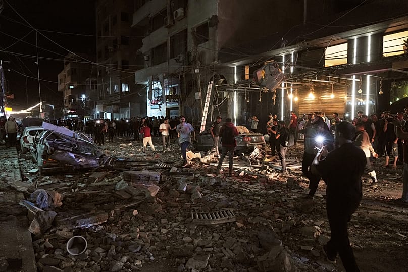 Palestinians inspect the site of an Israeli air strike in Gaza City, 26 May, 2026