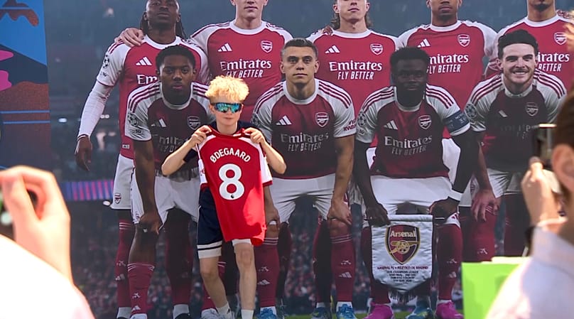 Un jeune supporter d'Arsenal se fait prendre en photo devant une image  de son équipe, à Budapest 