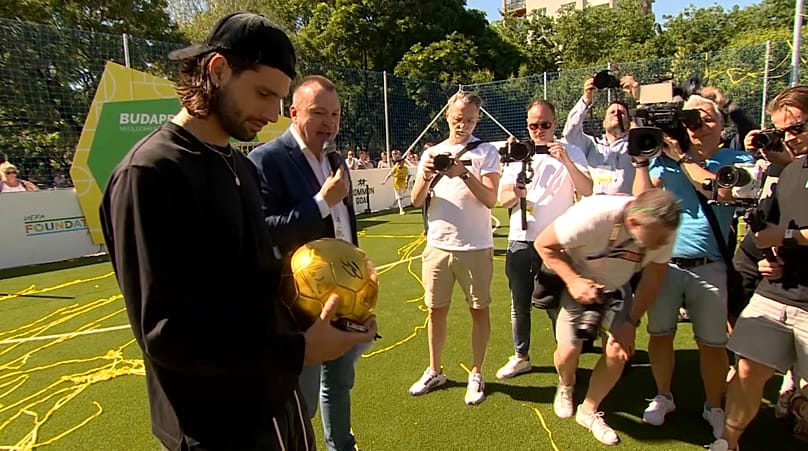 Le milieu de terrain hongrois Dominik Szoboszlai signe un ballon lors de l'inauguration du petit stade à Budapest