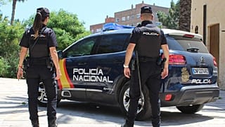Archivo: Dos agentes junto a un coche de la Policía Nacional de España