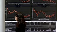 Υπάλληλος του χρηματιστηρίου περνά μπροστά από οθόνη που δείχνει τις μεταβολές των τιμών των μετοχών στην Αθήνα, Τετάρτη 9 Απριλίου 2014.