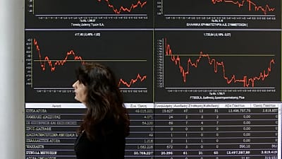 9 Nisan 2014 Çarşamba günü Atina'da, Borsanın bir çalışanı, hisse senedi fiyat hareketlerini gösteren bir ekranın önünden geçiyor.