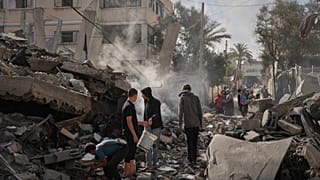 فلسطينيون يتفقدون أنقاض منزل عائلة الكرد الذي دمر في غارة جوية إسرائيلية في دير البلح بوسط قطاع غزة، الأحد 24 مايو 2026.