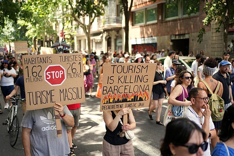 People march during a protest against overtourism in Barcelona, Spain, Sunday, June 15, 2025.