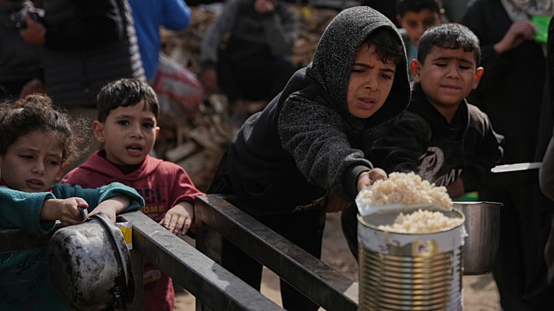 أطفال فلسطينيون يسعون للحصول على طعام من مطبخ في النصيرات وسط غزة 24 يناير 2026