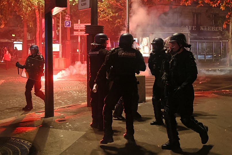 La police tente de disperser des supporters du PSG qui allument des feux d'artifice pour célébrer leur victoire à Paris, samedi 30 mai 2026, 