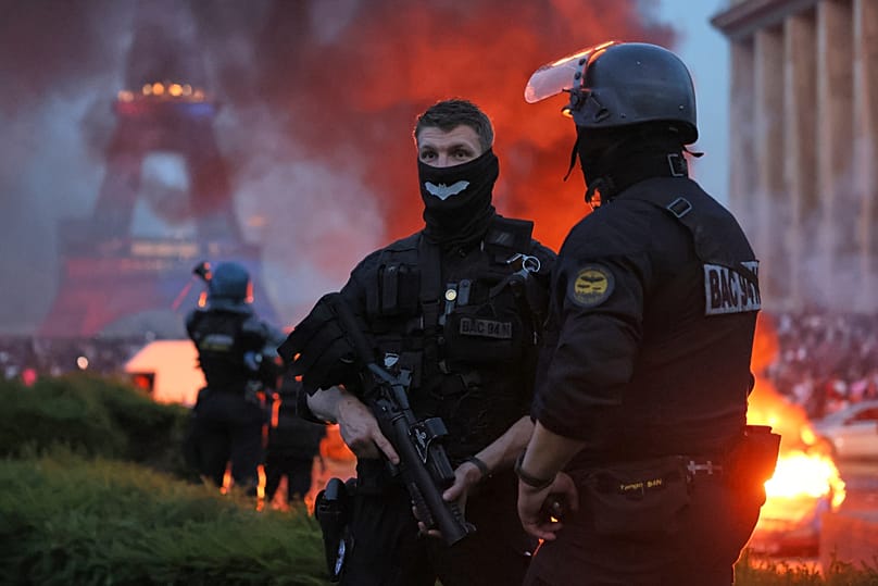 A car burns and fireworks explode as police watch PSG supporters celebrate in Paris, Saturday, May 30, 2026 after Champions League final soccer match between PSG and Arsenal