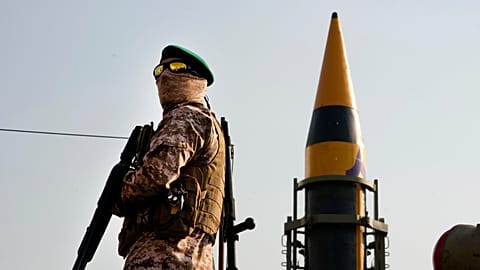 FILE: An IRGC member stands guard in front of a domestically built missile displayed during Basij paramilitary force rally in Tehran, 24 November 2023