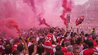 مشجعو أرسنال يلوحون بالأعلام ويشعلون الشماريخ بانتظار عرض الحافلة المكشوفة للفريق بعد التتويج بلقب الدوري الإنجليزي في لندن، 31 أيار 2026.