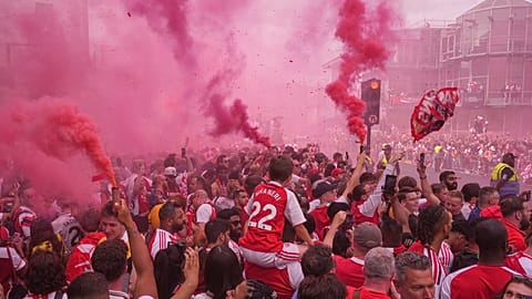 Arsenal fans wave flags and light flares while awaiting the team's open-top bus parade after the Premier League title win in London, May 31, 2026.