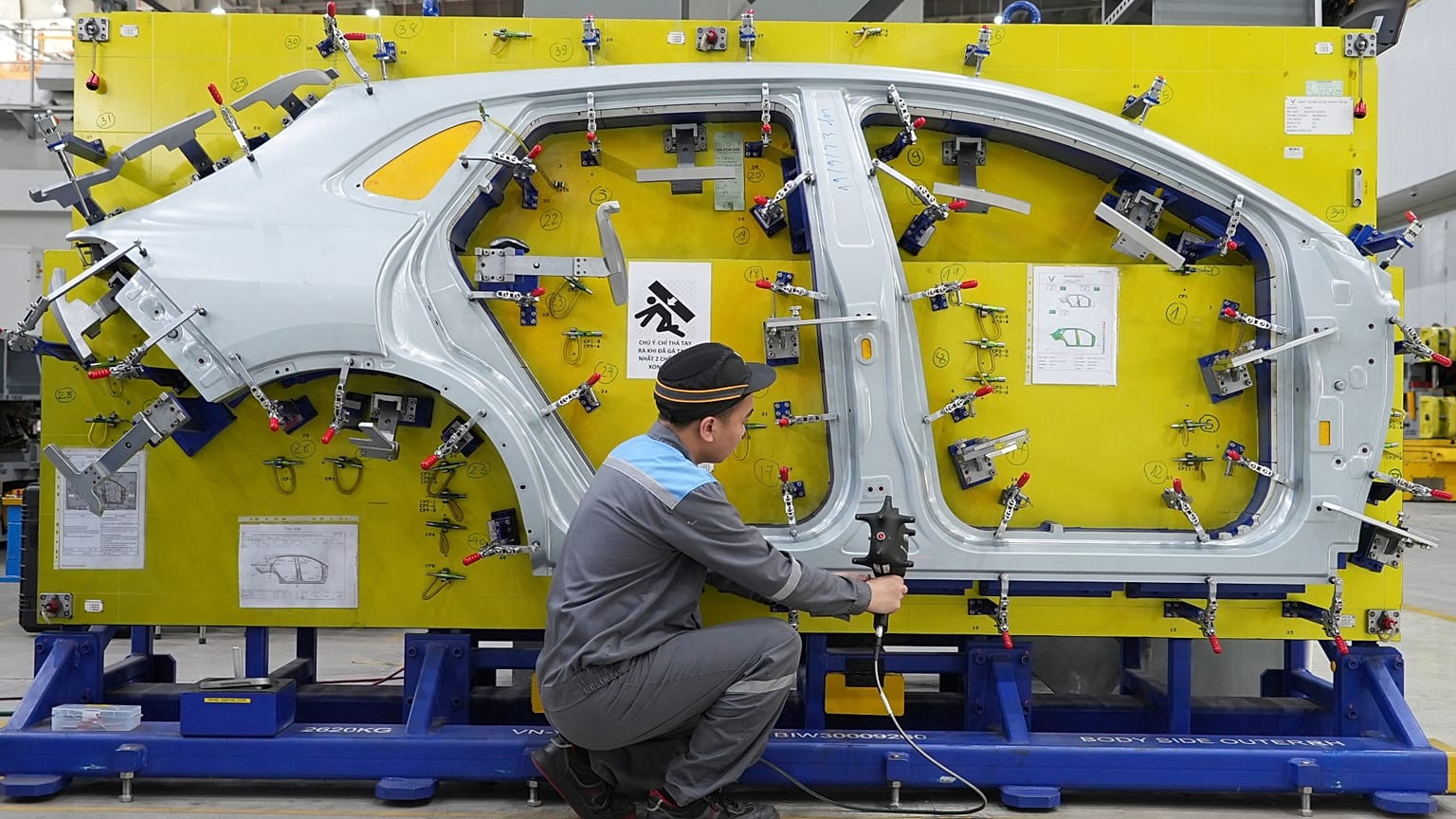 FILE. A worker examines a car frame at a Vinfast factory in Hai Phong, Vietnam, Sept. 2023