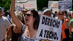 Eine Frau hält am Sonntag, 24. Mai 2026, bei einem Protest in Madrid, Spanien, ein Schild mit der spanischen Aufschrift „Recht auf Wohnen“.