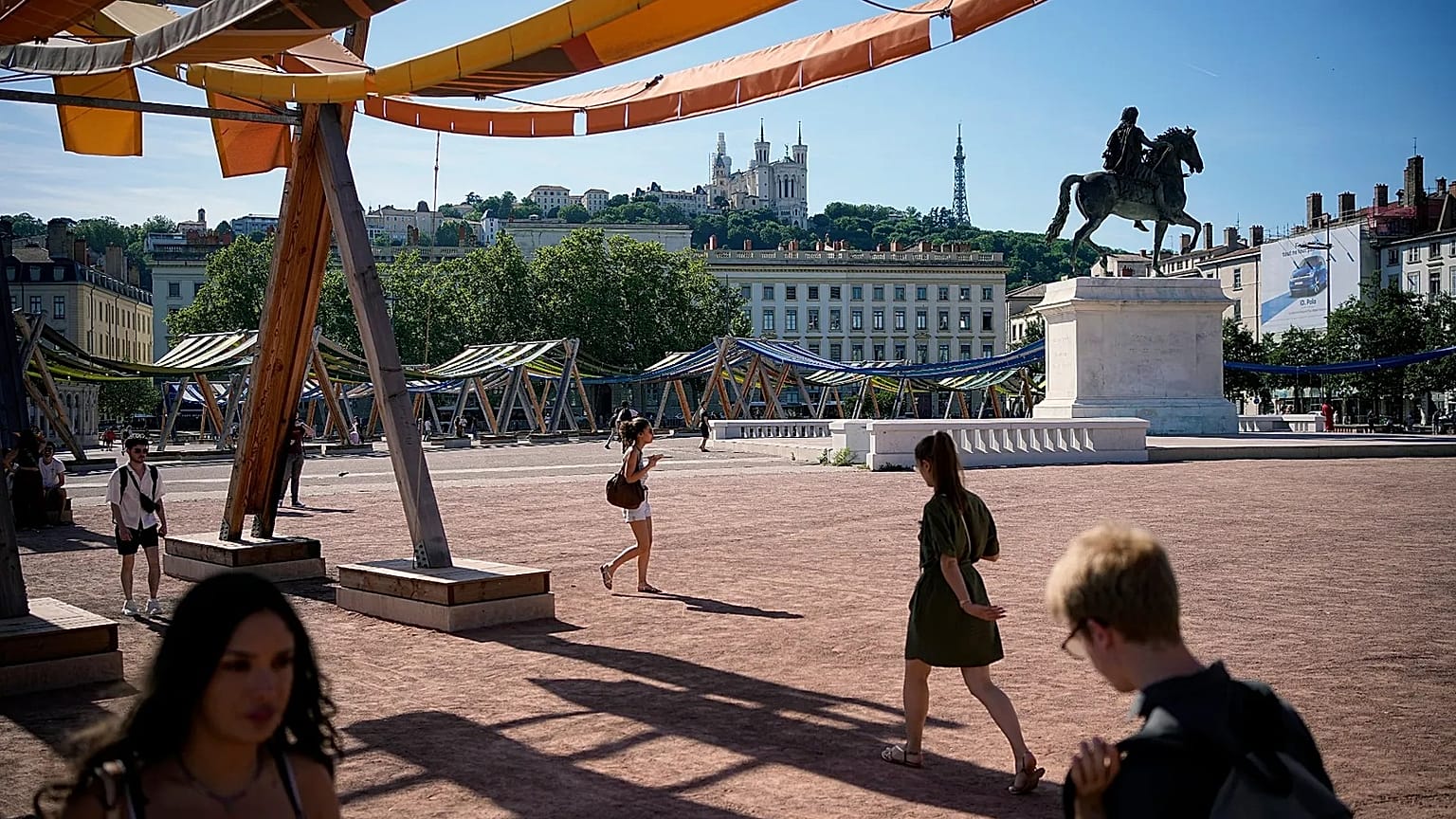 People walk during a heat wave, in Lyon, central France, Friday, May 29, 2026. 