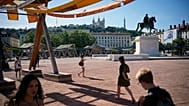 Des passants marchent sous la canicule, à Lyon, dans le centre de la France, vendredi 29 mai 2026.