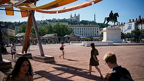 People walk during a heat wave, in Lyon, central France, Friday, May 29, 2026. 