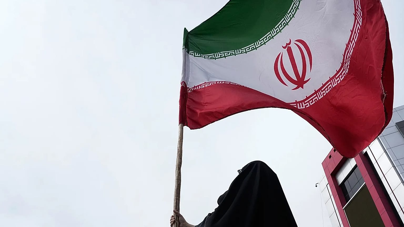 امرأة ترفع العلم الإيراني خلال حملة مؤيدة للحكومة في وسط العاصمة طهران، في 25 أبريل 2026.