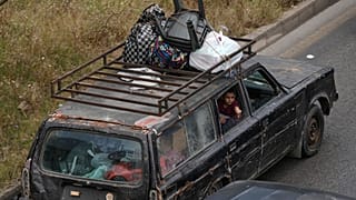 Család menekül Dahíjéből, Bejrút déli külvárosából az izraeli fenyegetést követően 