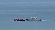 A boat thought to carry migrants is escorted by a vessel from the French Gendarmerie Nationale in the English Channel off Wimereux beach, 4 September, 2024