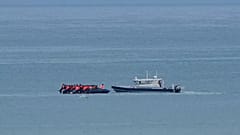 A boat thought to carry migrants is escorted by a vessel from the French Gendarmerie Nationale in the English Channel off Wimereux beach, 4 September, 2024