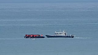 A boat thought to carry migrants is escorted by a vessel from the French Gendarmerie Nationale in the English Channel off Wimereux beach, 4 September, 2024