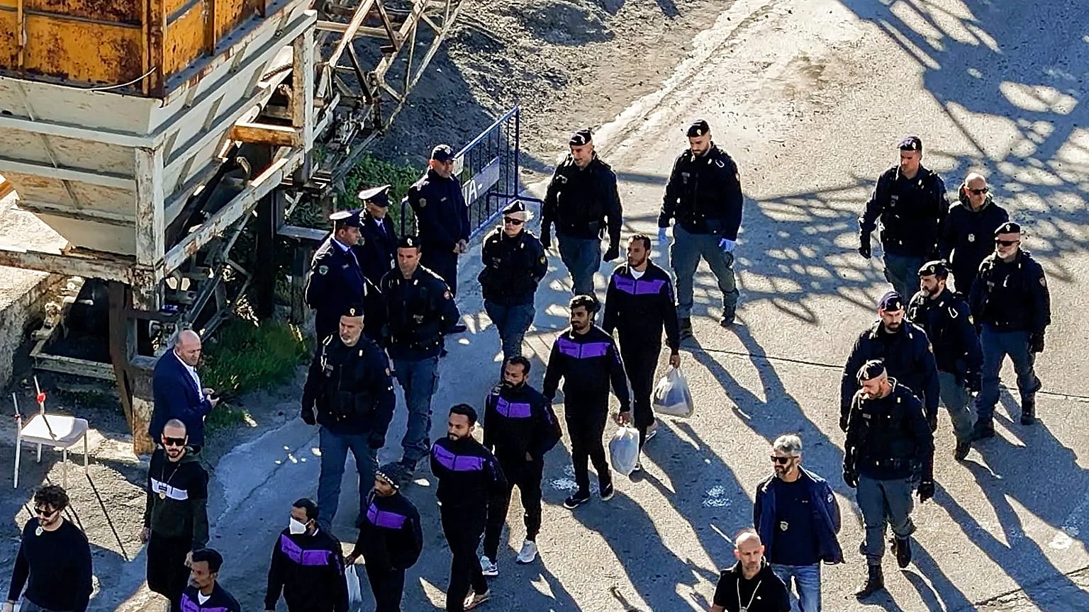 Migranci idą nabrzeżem w porcie Shengjin w Albanii po zejściu z okrętu włoskiej marynarki wojennej. 