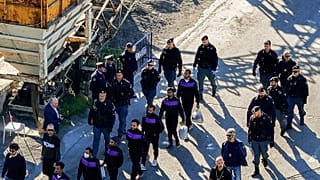 Migrants walk at the port of Shengjin, Albania, after they disembark from an Italian Navy ship. Italy built two deportation centres in Albania