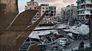 Un edificio distrutto, colpito da un attacco aereo israeliano, attraverso una finestra in frantumi dell'ospedale Jabal Amel, nella città di Tiro, in Libano