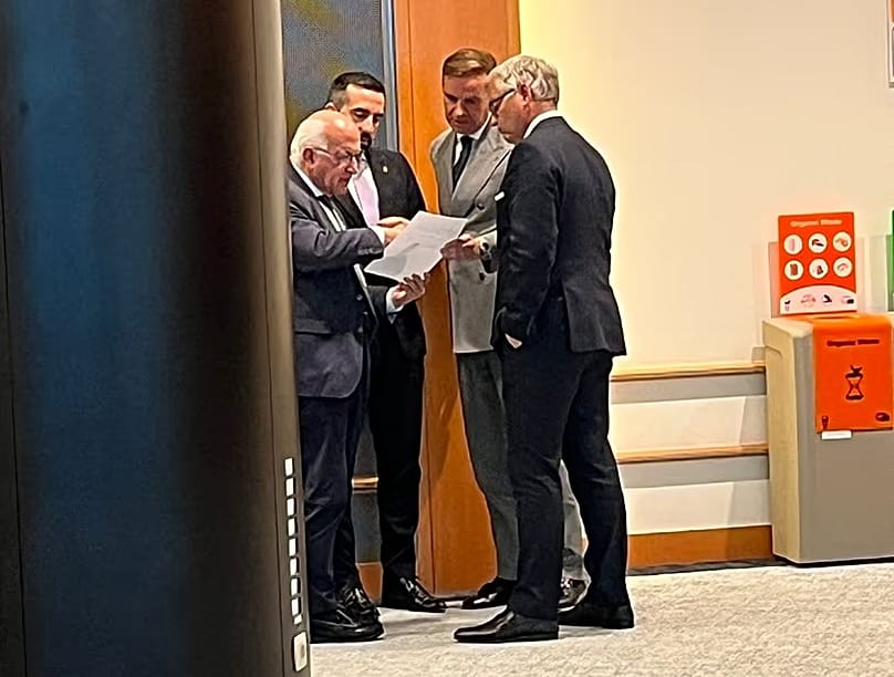 Il commissario europeo agli Affari interni Magnus Brunner parla con i rappresentanti del Parlamento e del Consiglio fuori dalla sala