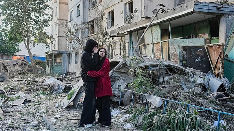Passanten reagieren an der Einschlagstelle eines russischen Raketenangriffs auf ein Wohnhaus in Kyjiw, Ukraine, Dienstag, den zweiten Juni 2026. (AP Photo/Efrem Lukatsky)