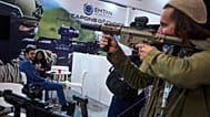 Des visiteurs examinent des armes exposées lors d'un salon de l'industrie de la défense à Tel-Aviv, en Israël, le mardi 17 février 2026. 