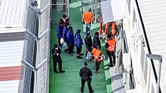 An aerial photograph taken by a drone shows migrants entering a detention center for processing following earlier court rejections, in the port of Shengjin