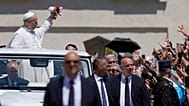 El Papa León XIV atrapa una pequeña muñeca mientras se desplaza en el Papamóvil al abandonar la Plaza de San Pedro en el Vaticano, el 28 de mayo de 2025.