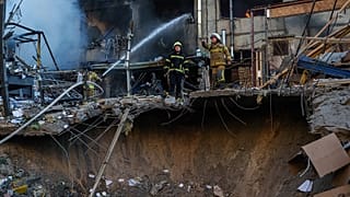 Socorrista apaga incêndio em edifício danificado após ataque russo a Kiev, 2 de junho de 2026