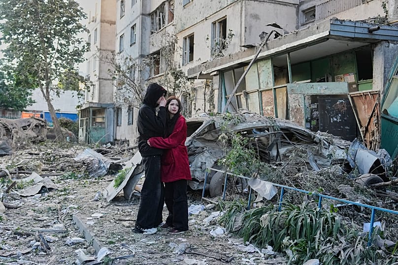 People react as they look at the site of a Russian missile strike that hit a residential building in Kyiv, 2 June, 2026