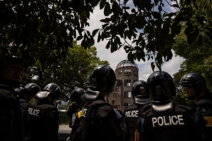 Police officers in riot gear patrol outside the Atomic Bomb Dome in Hiroshima, 5 August, 2025 