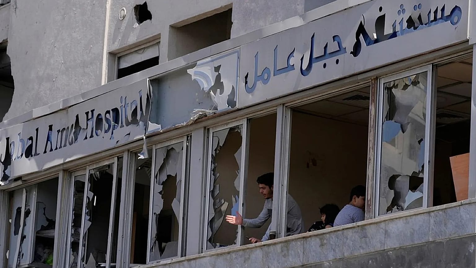 ينظر رجل من خلال النوافذ المحطمة لمستشفى جبل عامل المتضرر، في أعقاب الغارة الإسرائيلية التي استهدفت مبنى مجاوراً يوم الاثنين، في مدينة صور، الثلاثاء 2 يونيو 2026. 