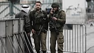 جنود إسرائيليون يدققون في هوية فلسطيني عند أحد الحواجز في بيت لحم أثناء توجهه إلى المسجد الأقصى لأداء أول صلاة جمعة من شهر رمضان، في 7 مارس 2025.
