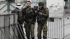 جنود إسرائيليون يدققون في هوية فلسطيني عند أحد الحواجز في بيت لحم أثناء توجهه إلى المسجد الأقصى لأداء أول صلاة جمعة من شهر رمضان، في 7 مارس 2025.